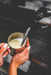 barista hand preparing hot milk on coffee machine