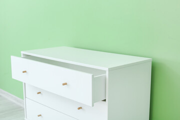 Stylish chest of drawers near color wall