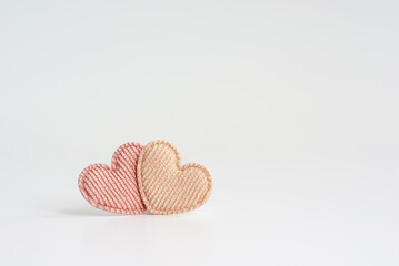 Two small pastel colored striped textile hearts stands together