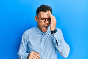 Young hispanic man wearing casual clothes and glasses yawning tired covering half face, eye and mouth with hand. face hurts in pain.