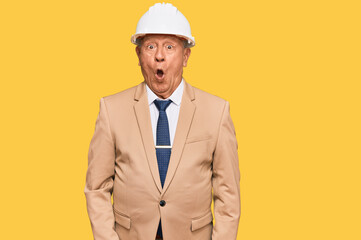 Senior caucasian man wearing architect hardhat scared and amazed with open mouth for surprise, disbelief face