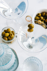 Martini cocktail in a glass on white background with olives. top view