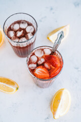 Fresh beverage with strawberry and lemon on the table. Summer refreshing drink