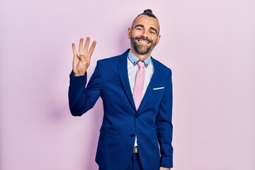 Young hispanic man wearing business suit and tie showing and pointing up with fingers number four while smiling confident and happy.