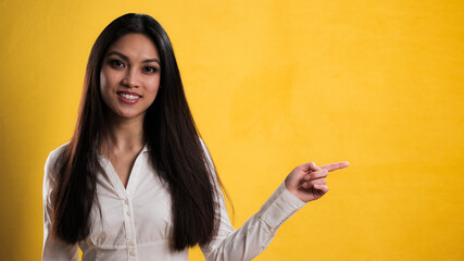 Young pretty woman points to something - studio photography