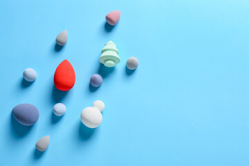 Different makeup sponges on color background