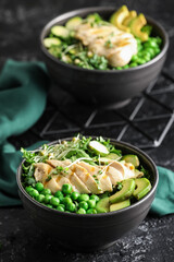 Bowls of tasty salad with fresh vegetables and chicken on dark background