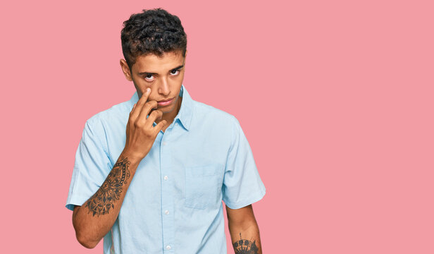 Young handsome african american man wearing casual clothes pointing to the eye watching you gesture, suspicious expression