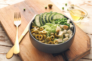 Bowl of tasty salad with fresh vegetables on wooden background