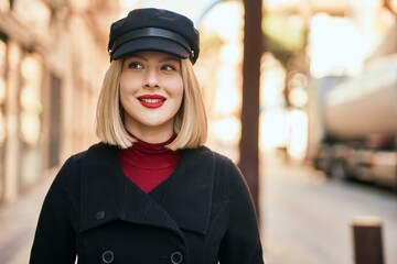 Young blonde woman smiling happy standing at the city.