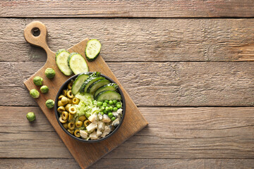 Bowl of tasty salad with fresh vegetables on wooden background