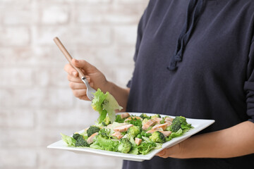 Woman eating tasty salad with fresh vegetables and chicken, closeup