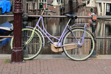 Fototapeta na wymiar Purple and Green Painted Bicycle on an Amsterdam Bridge in the Red Light District