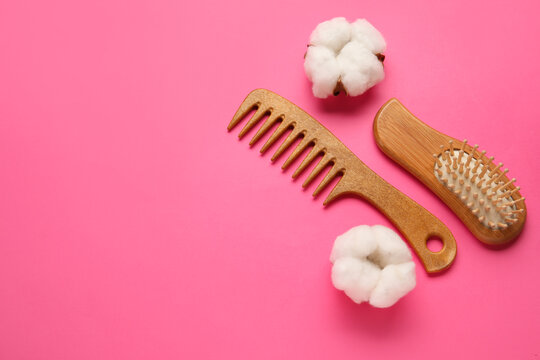 Wooden hair comb and brush on color background