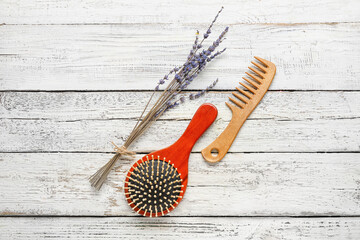 Hair comb and brush on white wooden background