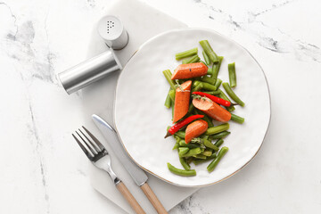 Plate with tasty sausage, green beans and chili pepper on light background