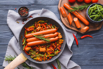 Composition with tasty sausages and vegetables on wooden background