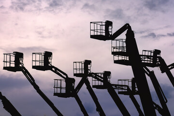 Silhouettes of aerial work platforms (AWP), also known as aerial devices, elevating work platforms...