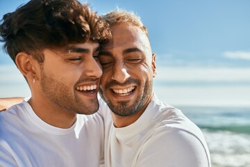Young gay couple smiling happy hugging at the beach. - Powered by Adobe