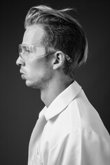 Young handsome man doctor as scientist with protective glasses