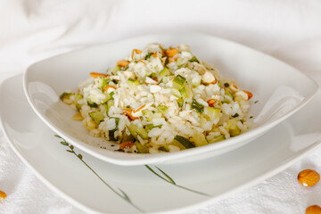 Vegan zucchini risotto with almonds in a white ceramic dish-1