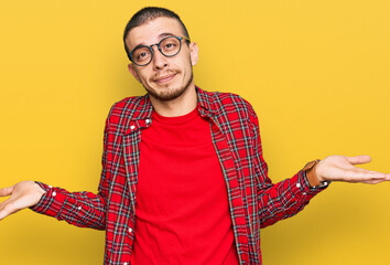 Hispanic young man wearing casual clothes smiling showing both hands open palms, presenting and...