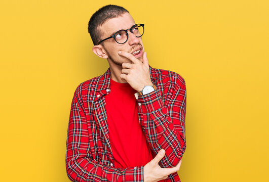 Hispanic young man wearing casual clothes thinking worried about a question, concerned and nervous with hand on chin