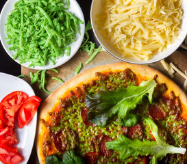 Hot pizza with green cheese and ingredients
