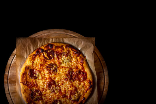 Hot Pizza On Baking Paper On Wooden Plate