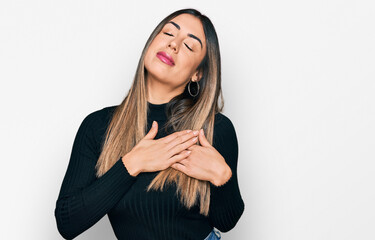 Young hispanic woman wearing casual clothes smiling with hands on chest with closed eyes and grateful gesture on face. health concept.
