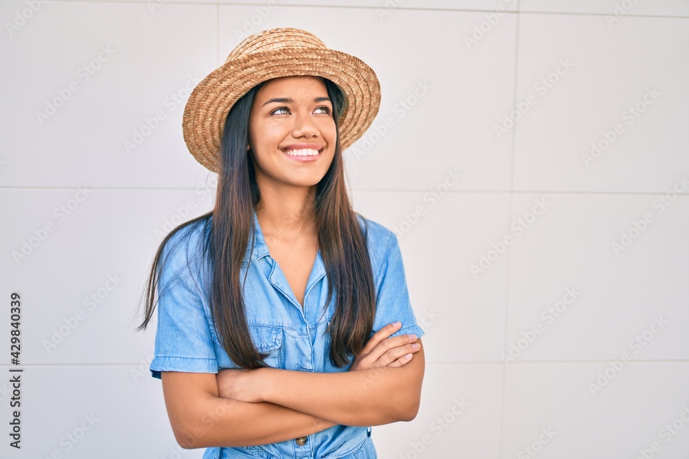 Sticker Young latin tourist girl on vacation smiling happy walking at the city.