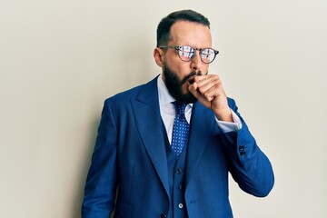 Young man with beard wearing business suit and tie feeling unwell and coughing as symptom for cold or bronchitis. health care concept.