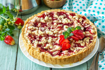 Homemade baking. Summer dessert. Strawberry pie with crumbs and fresh strawberries on a wooden rustic table.