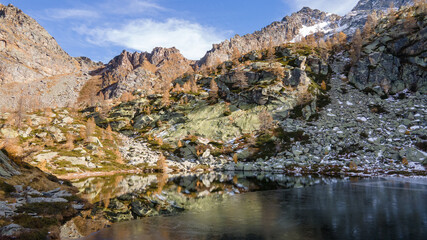 Colorful autumn view of small mountain lake with water reflection. italian alps