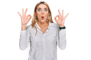 Young caucasian woman wearing casual clothes looking surprised and shocked doing ok approval symbol with fingers. crazy expression