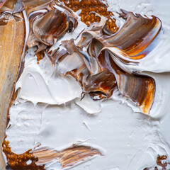 .Embossed pasty oil paints and reliefs. Primary colors: brown, white, yellow, orange. Abstract art. Mix of paints.