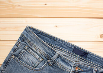 Blue jeans on a wooden background, texture of denim. Top view.