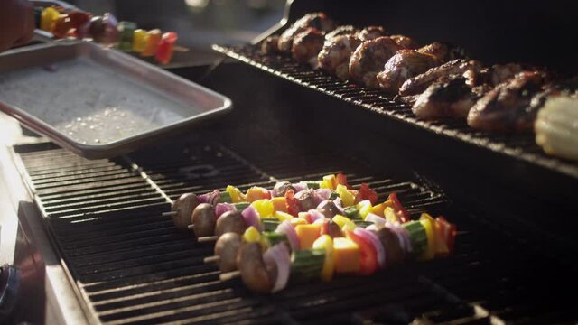 Grillmaster places his famous shish kabobs on the smoking grill