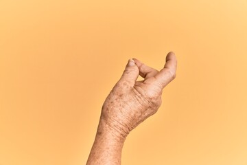 Senior caucasian hand over yellow isolated background snapping fingers for success, easy and click symbol gesture with hand
