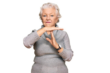 Senior grey-haired woman wearing casual winter sweater doing time out gesture with hands,...