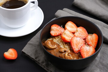 Oatmeal with strawberries and coffee. Cooking. Food.
