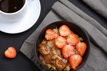 Oatmeal with strawberries and coffee. Cooking. Food.