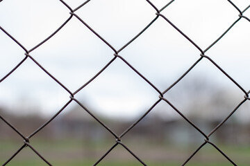 Blurry background behind a metal mesh fence