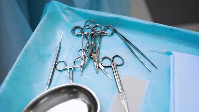 Modern medical concept. Surgical tools, steel medical instruments including scalpels, forceps and tweezers lie on medical table. preparation for operation. Surgery and emergency concept.