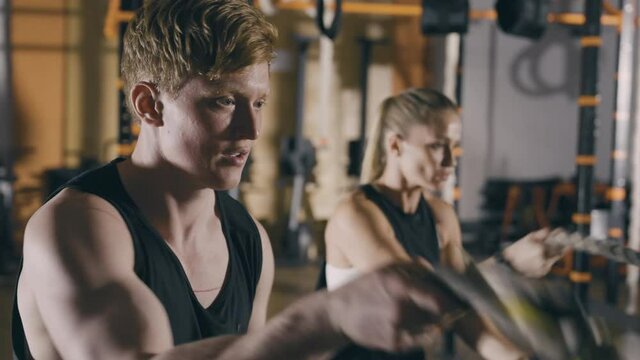 Two fitness person working out with battle ropes