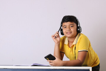 indian child attending online classes on mobile.