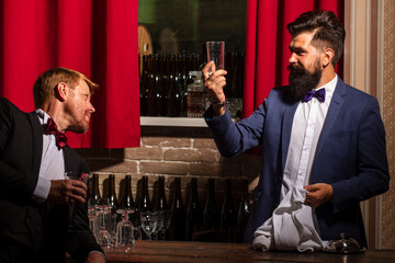 Barmen and customer. Alcohol beverage. Barman at counter. Hipster in bar. Old traditional whiskey drink. Gentlemans beverage.