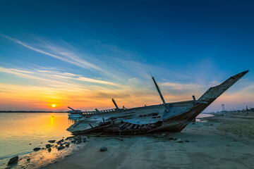 A broken old wooden fishing boat abandoned at Dammam Corniche, Kingdom of Saudi Arabia.