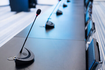 Close-up of microphones in an empty meeting room at a press conference.