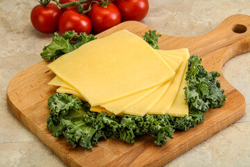 Sliced Gauda cheese over board